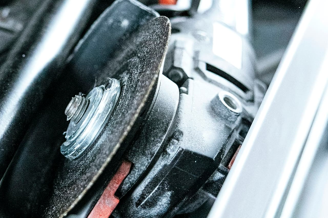 An angle grinder is packed beside other tools inside an aluminium-edged portable case.