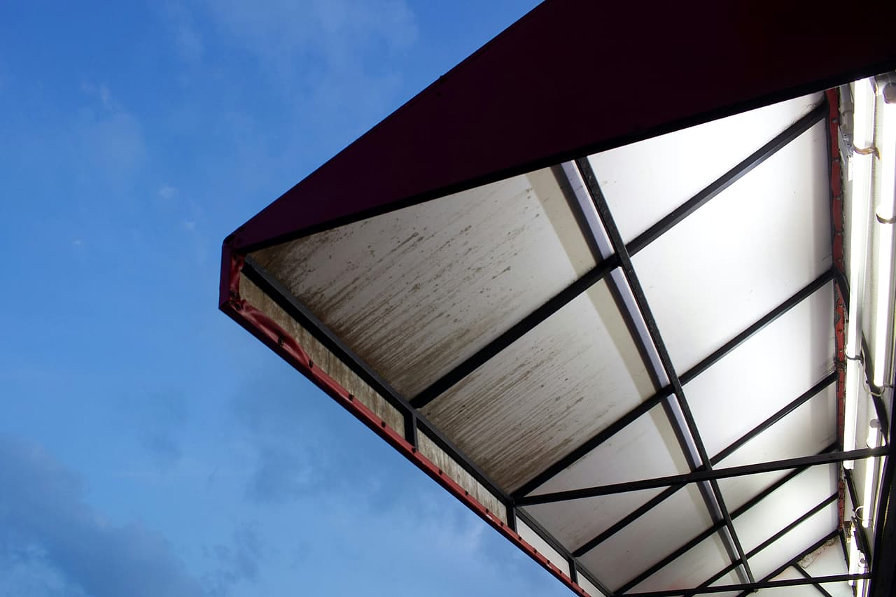 Metal-framed canopy viewed from below against the sky.