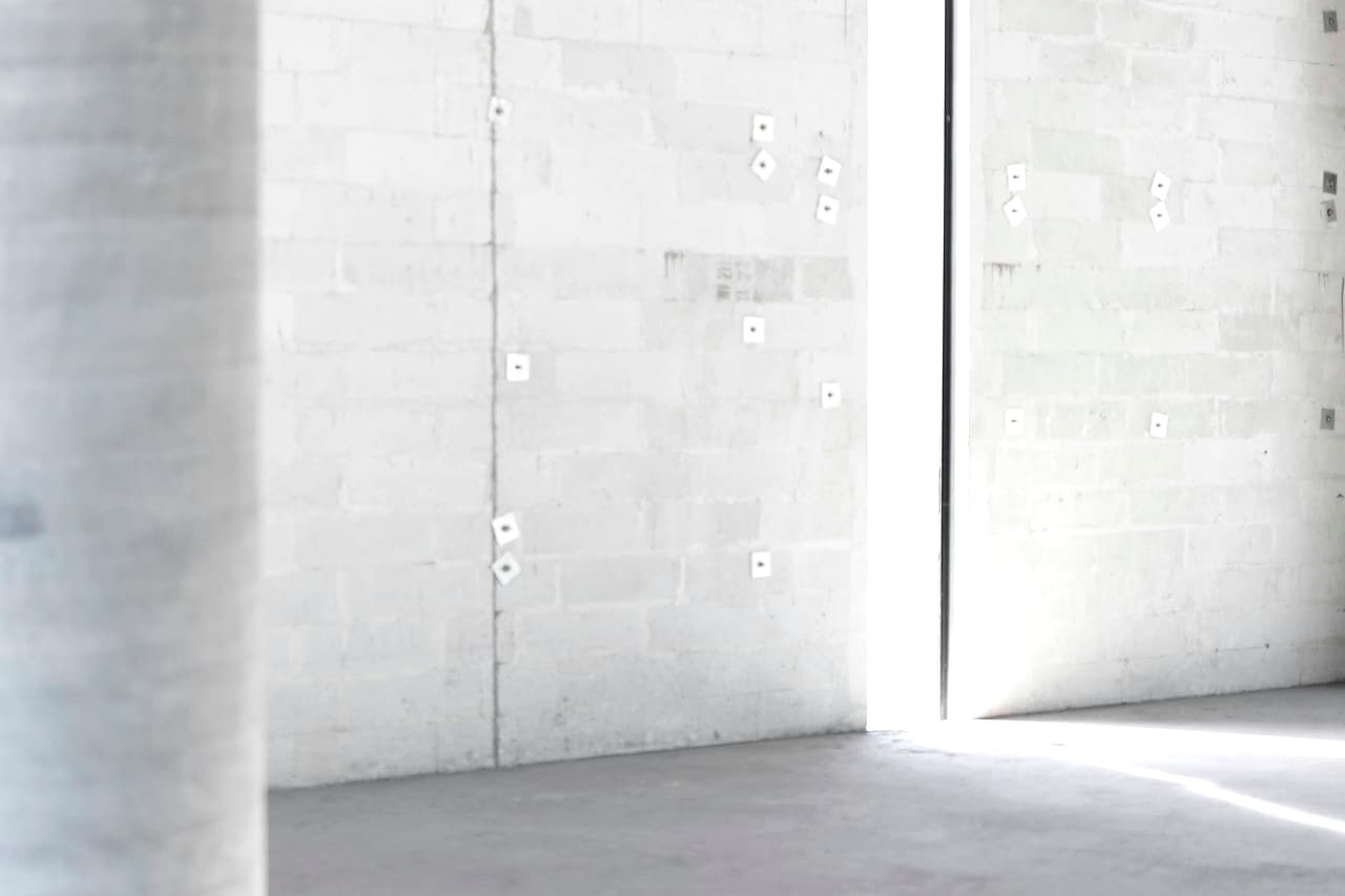 Sunlight crosses a clear concrete floor beside bare block walls and an empty doorway.