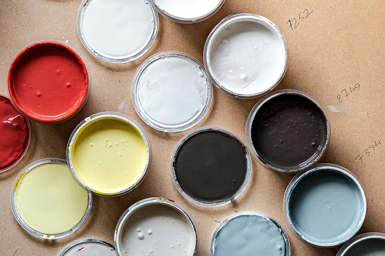 Open paint sample pots show several finish colours.