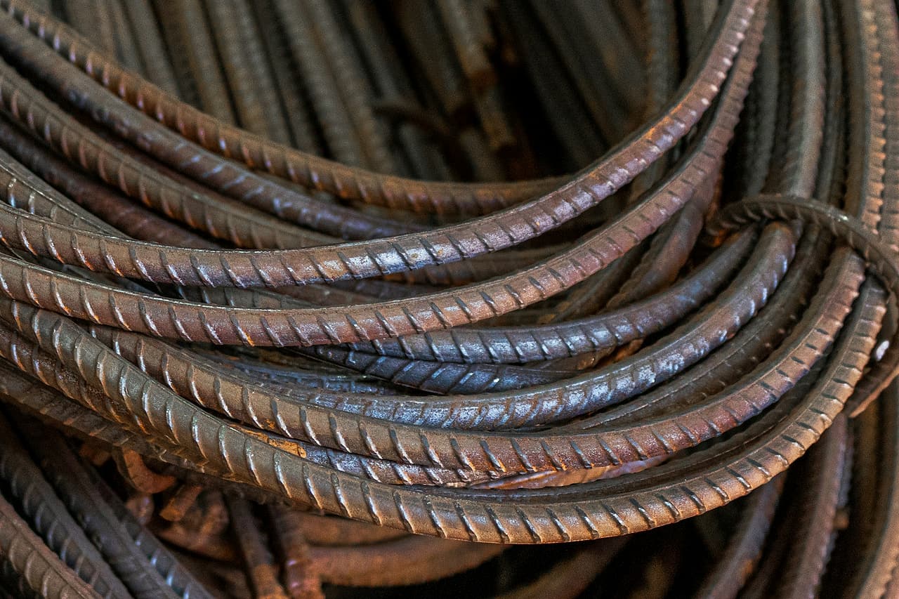 Curved reinforcing steel bars are bundled together in a close view of their ridged surfaces.