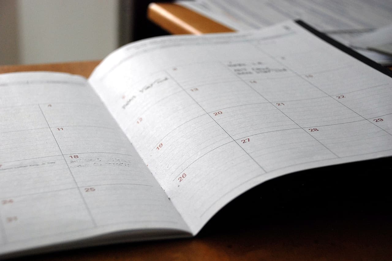 An open planner shows the dates of a month.