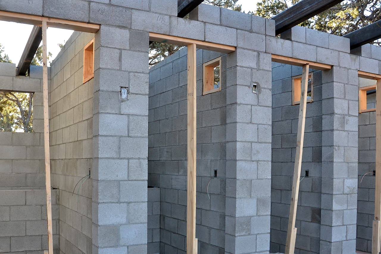 Unfinished concrete-block walls and framed openings show repeated masonry work.